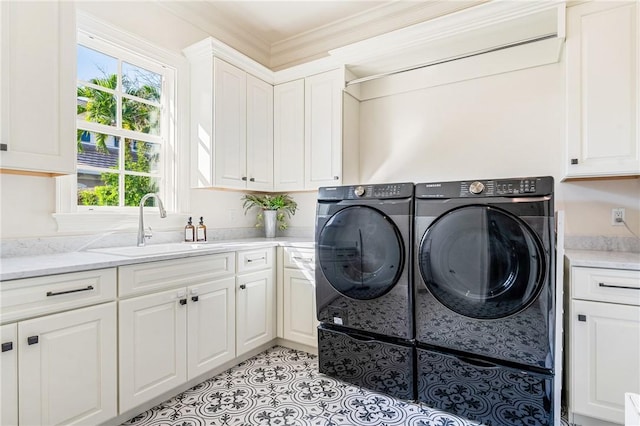 washroom with sink, crown molding, light tile patterned floors, washing machine and dryer, and cabinets