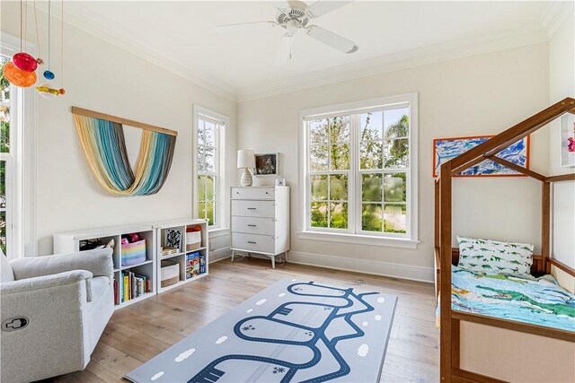 bedroom with crown molding, multiple windows, and light wood-type flooring