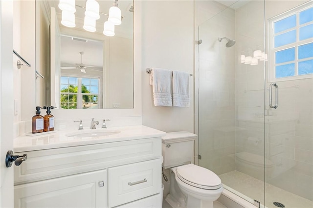 bathroom with vanity, a shower with shower door, ceiling fan, and toilet