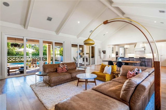 living room with beamed ceiling, light wood-type flooring, high vaulted ceiling, and french doors