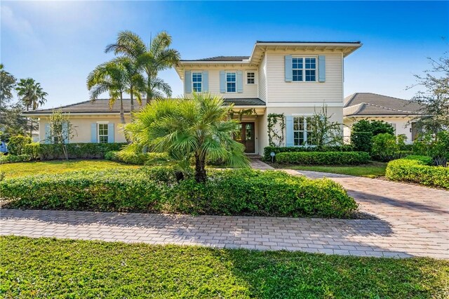 221 Palm Island Ln, Vero Beach, FL 32963 - view of front of property with a front yard, curved driveway, and stucco siding