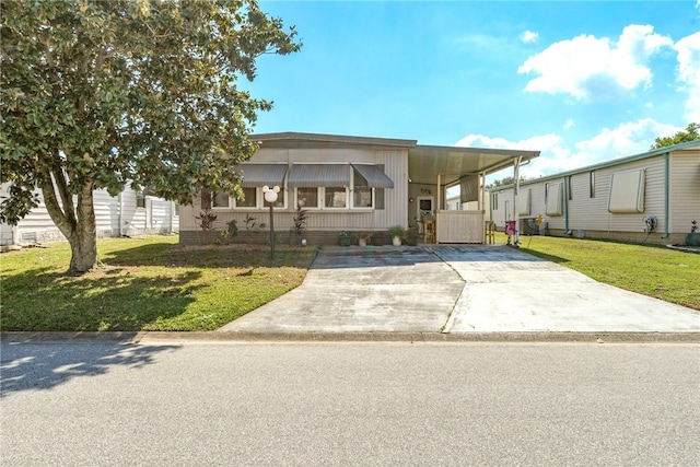 view of front of property with a carport and a front lawn