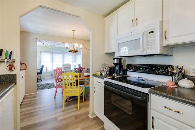 kitchen featuring white appliances, light hardwood / wood-style flooring, white cabinetry, hanging light fixtures, and a notable chandelier