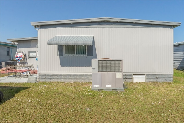 view of home's exterior with cooling unit, a lawn, and a patio area