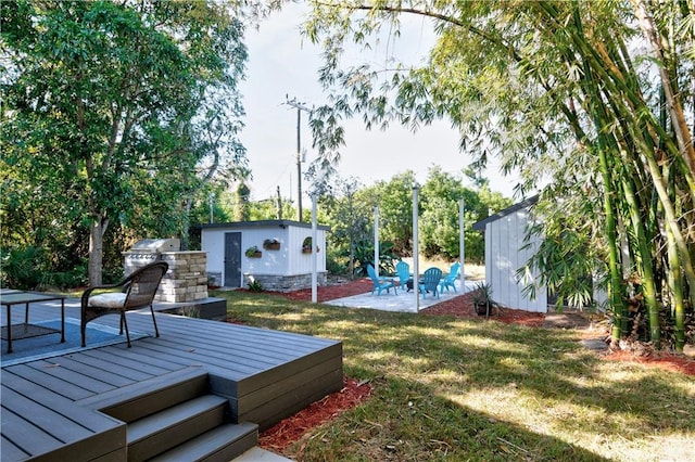 view of yard with a wooden deck, a patio area, and a shed