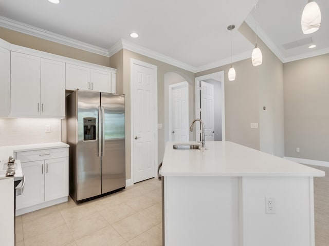 kitchen featuring a center island with sink, sink, stainless steel refrigerator with ice dispenser, white cabinets, and pendant lighting