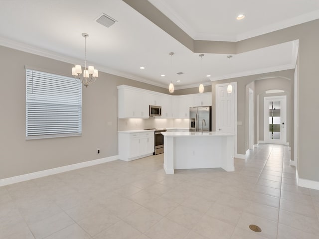 kitchen featuring white cabinetry, appliances with stainless steel finishes, a center island with sink, and crown molding