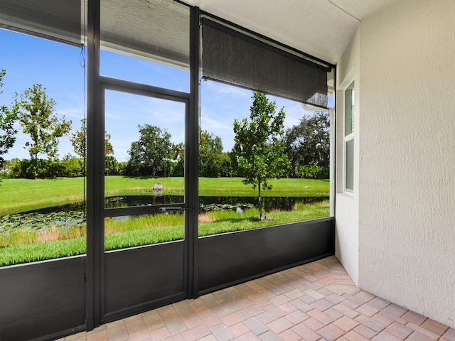 unfurnished sunroom featuring a water view