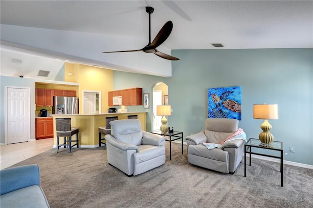 living room featuring vaulted ceiling, light carpet, and ceiling fan