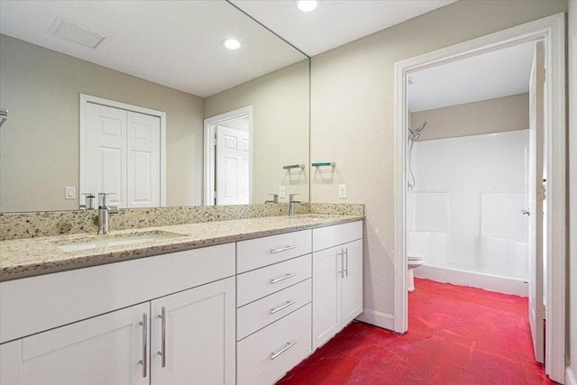 bathroom featuring a shower, vanity, and toilet