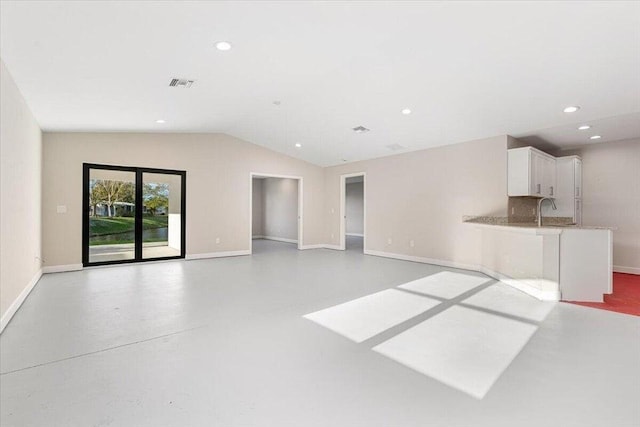 unfurnished living room with sink and vaulted ceiling