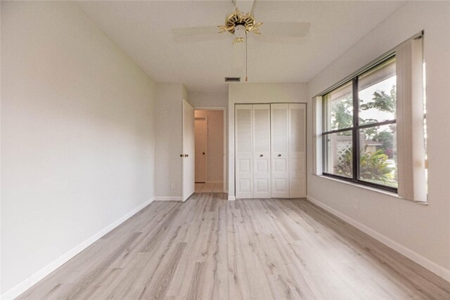 unfurnished bedroom with light hardwood / wood-style flooring, ceiling fan, and a closet