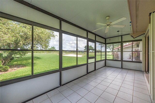 unfurnished sunroom featuring ceiling fan