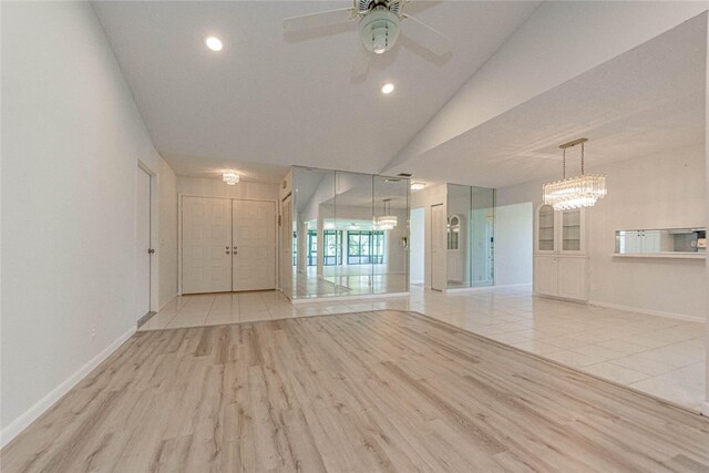 unfurnished room featuring light wood-type flooring, lofted ceiling, and ceiling fan