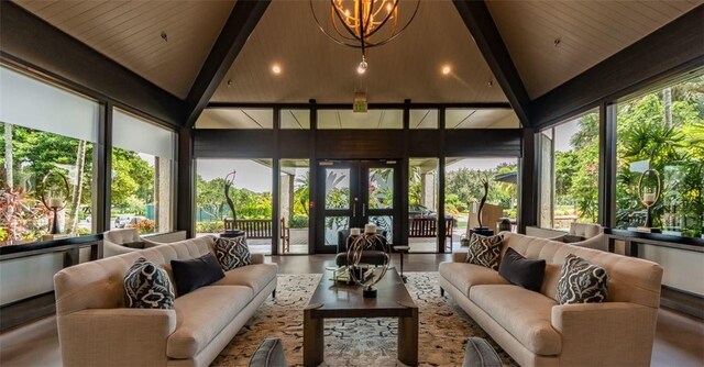 sunroom with lofted ceiling with beams, a notable chandelier, and a healthy amount of sunlight