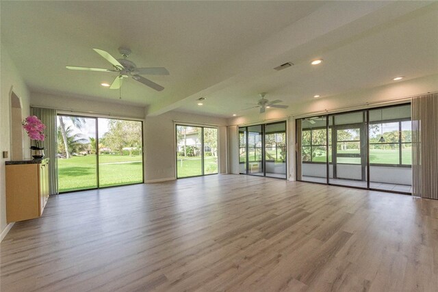 empty room with light hardwood / wood-style flooring, ceiling fan, and plenty of natural light