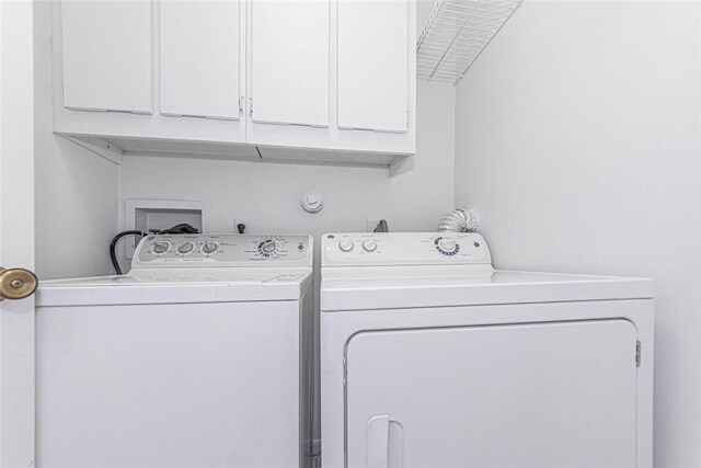 washroom with cabinets and washer and dryer