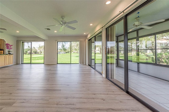 unfurnished sunroom featuring ceiling fan