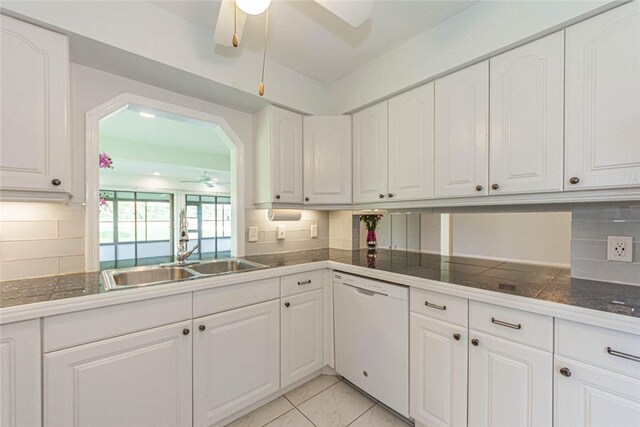 kitchen featuring tasteful backsplash, sink, white dishwasher, and white cabinets