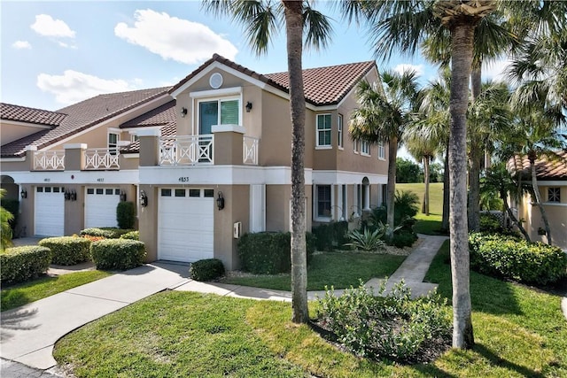 view of front of home with a balcony, driveway, a front lawn, a tile roof, and stucco siding