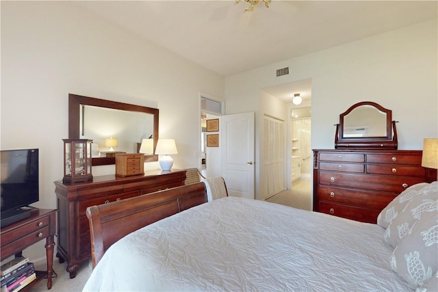 bedroom with light colored carpet, visible vents, and ensuite bath