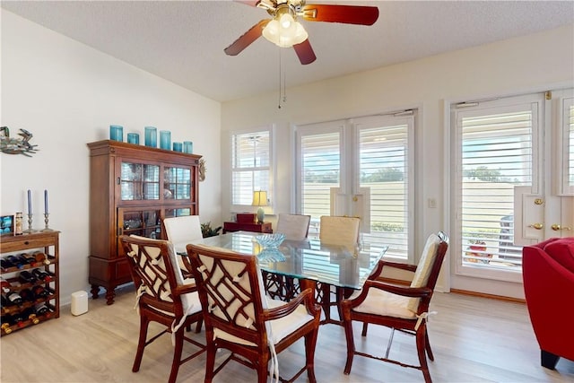 dining room with ceiling fan, a textured ceiling, and light wood-type flooring