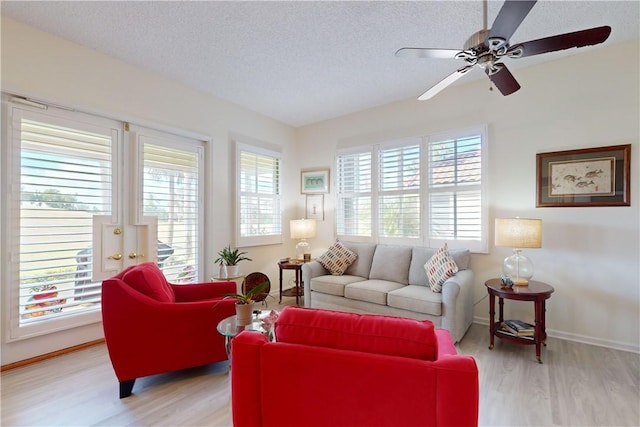 living room with a healthy amount of sunlight, a textured ceiling, and light hardwood / wood-style flooring