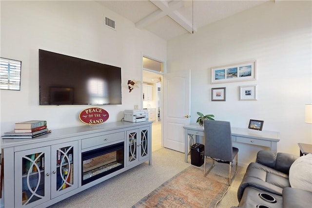 home office featuring light colored carpet, visible vents, and beamed ceiling