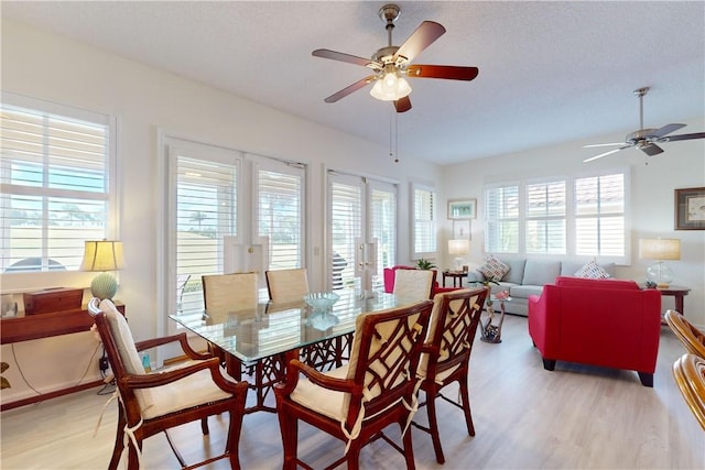 dining space with ceiling fan and light wood-style floors