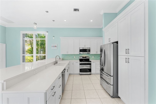 kitchen with white cabinetry, kitchen peninsula, sink, appliances with stainless steel finishes, and pendant lighting