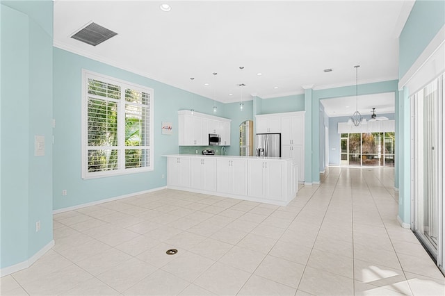 kitchen featuring appliances with stainless steel finishes, plenty of natural light, white cabinetry, and hanging light fixtures