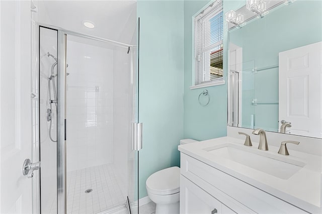 bathroom with vanity, a shower with door, and toilet