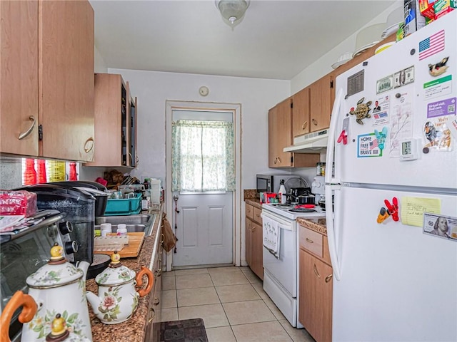 kitchen with white appliances, under cabinet range hood, and light tile patterned floors
