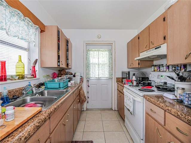 kitchen featuring under cabinet range hood, white range with electric stovetop, a sink, light tile patterned floors, and glass insert cabinets