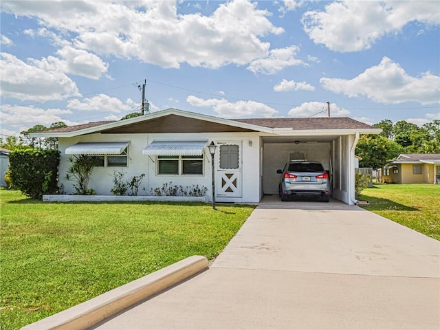single story home featuring a front yard, driveway, an attached carport, and stucco siding