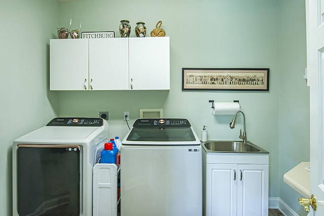 clothes washing area with sink, cabinets, and independent washer and dryer