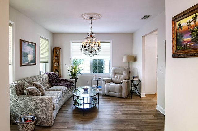 living room with a chandelier and dark hardwood / wood-style floors