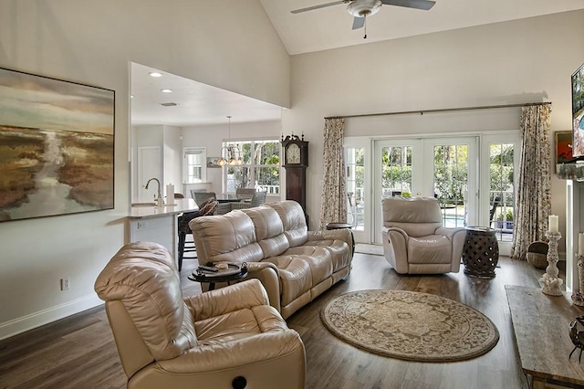 living room with ceiling fan, dark hardwood / wood-style flooring, high vaulted ceiling, and french doors