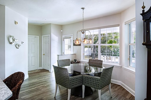 dining area featuring a notable chandelier and dark wood-type flooring