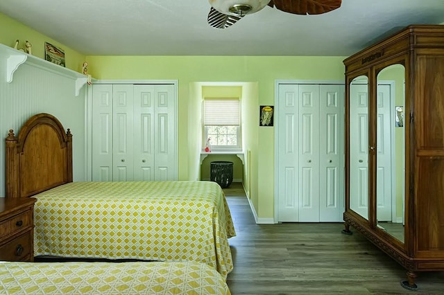 bedroom with ceiling fan, hardwood / wood-style floors, and multiple closets