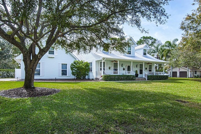 view of front of home with a garage, covered porch, and a front yard