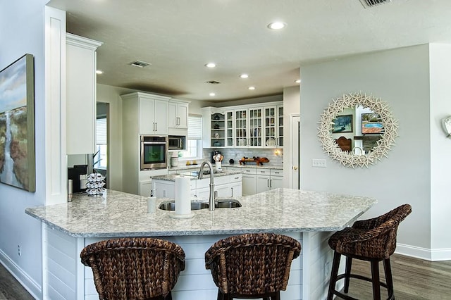 kitchen featuring white cabinetry, kitchen peninsula, and a breakfast bar area