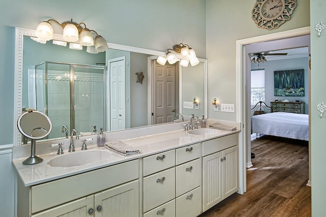 bathroom with crown molding, hardwood / wood-style flooring, walk in shower, vanity, and ceiling fan