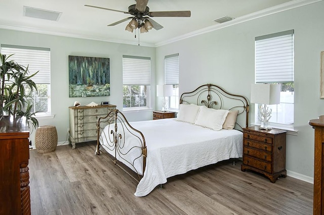 bedroom featuring ceiling fan, crown molding, and hardwood / wood-style floors