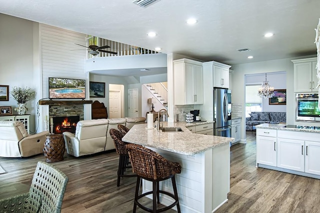 kitchen featuring white cabinetry, appliances with stainless steel finishes, and a fireplace