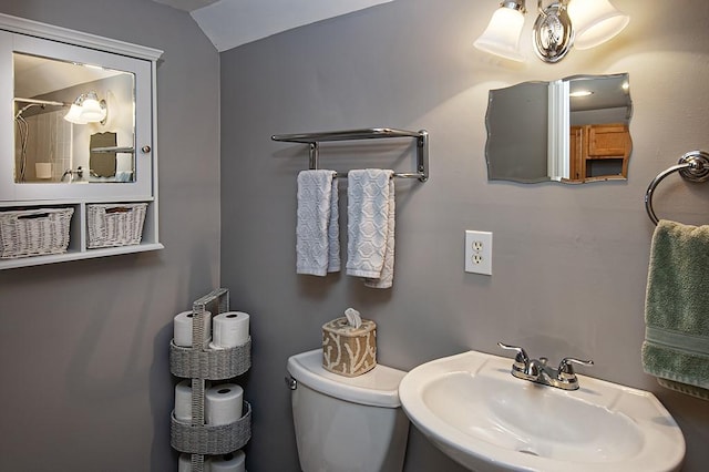 bathroom featuring sink, toilet, and lofted ceiling