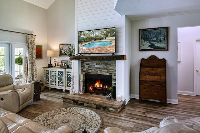 living room with hardwood / wood-style floors, vaulted ceiling, and a fireplace