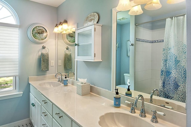 bathroom with plenty of natural light, curtained shower, toilet, and vanity