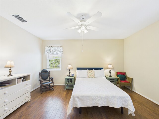 bedroom featuring wood finished floors, visible vents, a ceiling fan, and baseboards