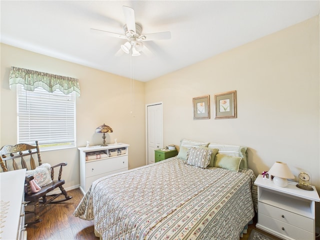 bedroom with a ceiling fan, a closet, wood finished floors, and baseboards